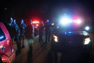 Police officers surrounding pulled over car