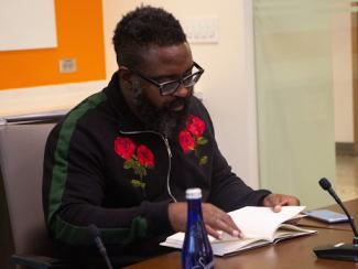 reginald betts sitting down and reading from a book