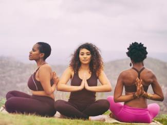 three black women practicing yoga