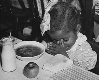 Young Black girl praying over school lunch