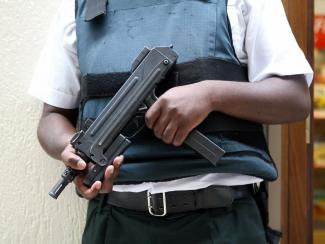 Person wearing bullet proof vest and holding riffle