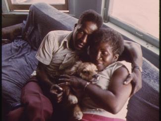 Man and woman hugging dog together