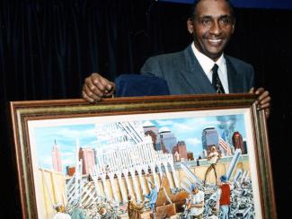 Ernie Barnes holding In Remembrance painting
