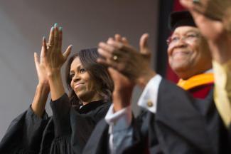 Michelle Obama clapping at a graduation