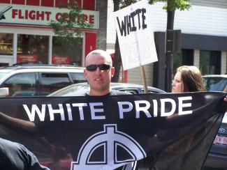 Man holding white pride sign