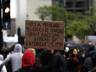 people holding protest signs at a rally