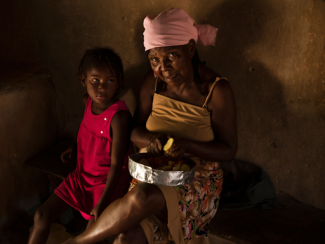 picture of a quilombo sitting down next to a child