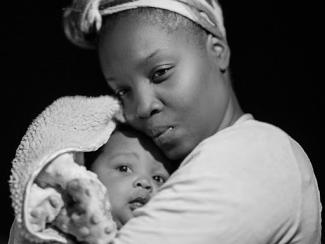 black woman holding her baby close