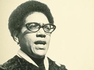 audre lorde speaking in a sepia tone photo