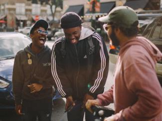 three black men standing together laughing