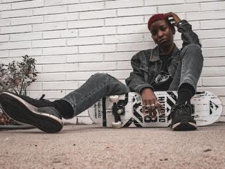 black skateboarder sitting down