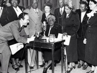 mary mcleod bethune signing documents surrounded by people