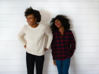 two black women standing together laughing