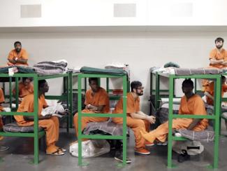 group of prisoners sitting on the bed