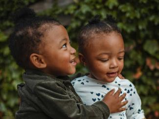 two black children surrounded by plants