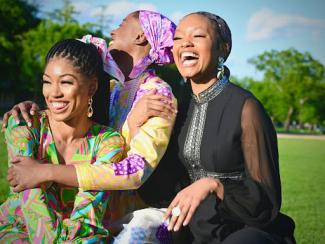 woman in black dress sitting beside woman in green and yellow dress 