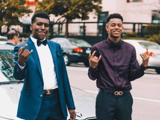 two black young men standing in front of a bmw