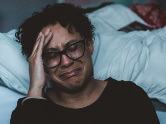 person with hand on forehead looking upset