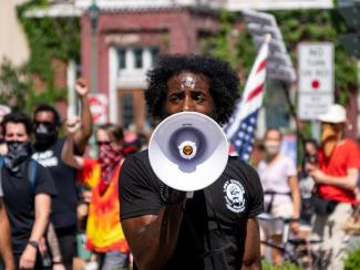 man in black crew neck t shirt speaking through bullhorn