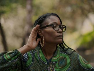 a black woman wearing glasses and a green shirt