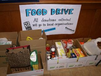 food drive sign with collection boxes in front of the sign