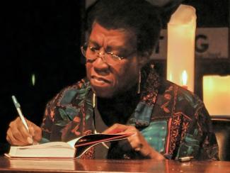 octavia butler signing the inside of a book cover