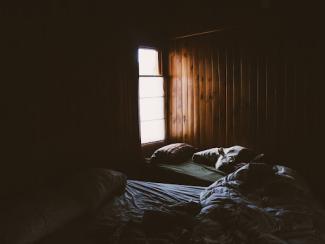 dark room with an open window and light shining through