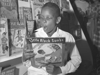 a little black boy reading a little black sambo book