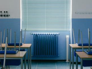 empty desks in front of a window with a radiator