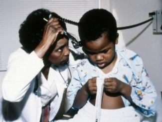 black doctor examining a child
