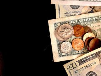 money with coins against a black background