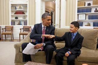 president obama sharing a dap with younger boy