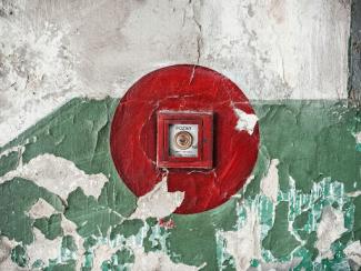 red button on a green and white wall