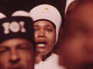 crowd of people gathered with one person having tears running their face