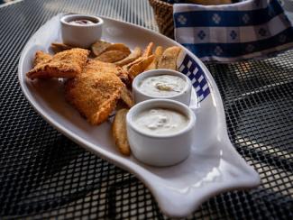 plate of food on a table with a view of a harbor