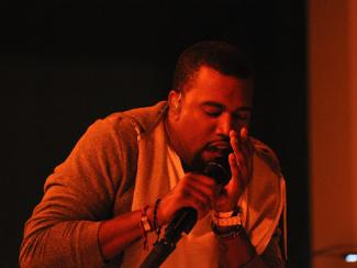 kanye west singing into a microphone