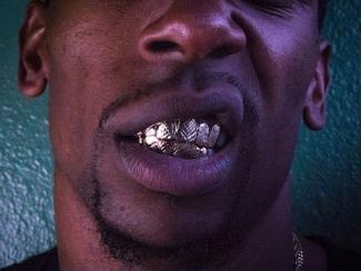 man smiling with a grill on 