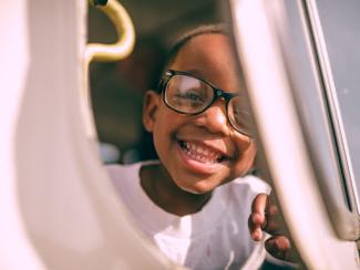 child looking through a gap and smiling