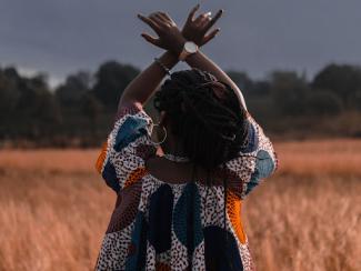 black person holding up arms crossed at wrist 