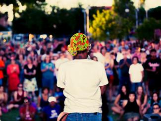 black woman speaking in front of a crowd at a rally