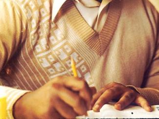black man writing in a notebook