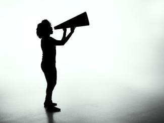 silhouette of a person shouting into a bullhorn