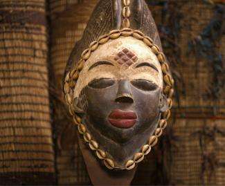 gold and black mask on brown brick wall 