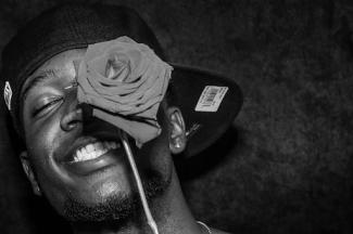 black man with a rose covering his face