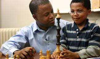 black man and younger black boy sitting together