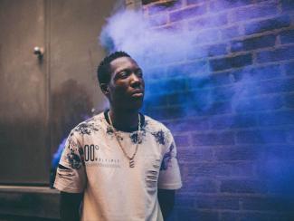 black man standing against a wall