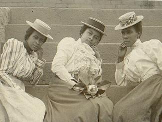 three black women sitting on stairs together