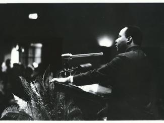 mlk speaking in front of an audience at a podium