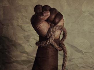 raised clenched fist with a rope tied around the wrist
