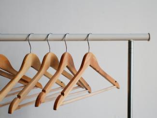 wooden hangers on a clothing rack
